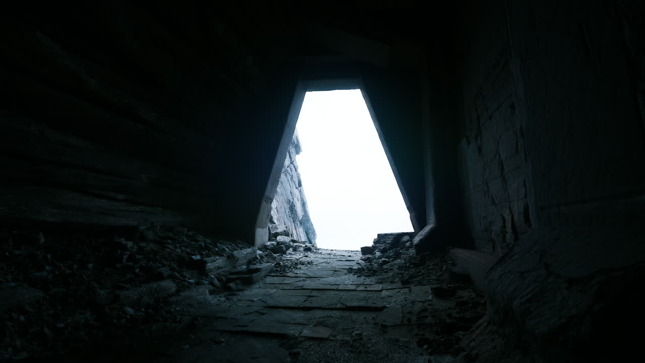 Mysterious approach to an ancient doorway with faint light at the end
