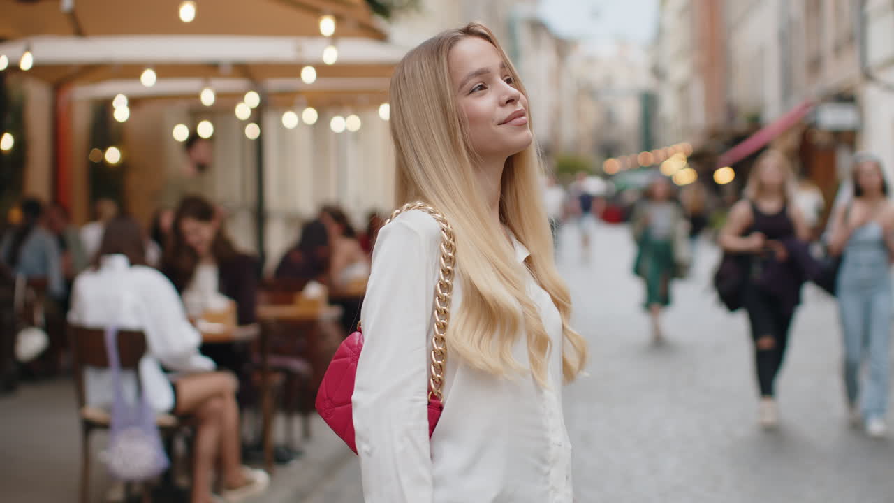 Portrait of young woman girl tourist walking in urban city street smiling having positive good mood