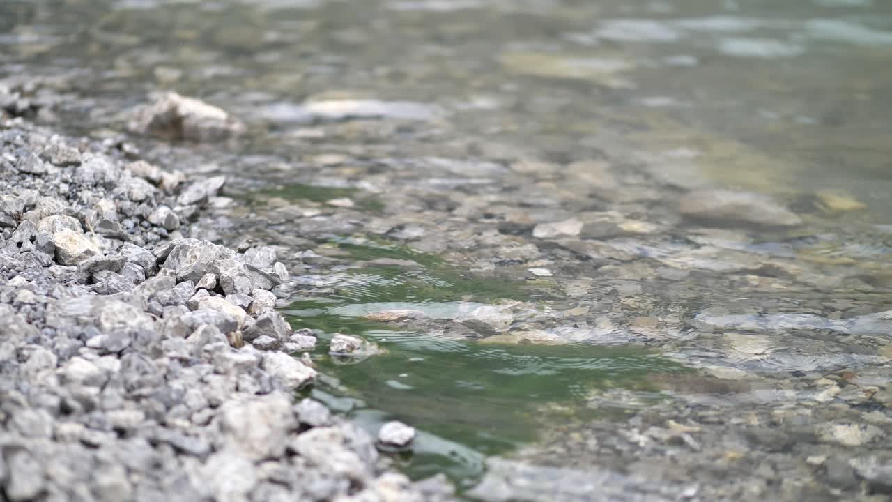 Crystal Clear River Water Rippling With Rocks And Stones At The Bottom - close up