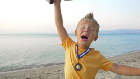 little winner boy with medal and cup