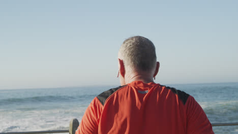 senior man using wireless earphones while running in the park