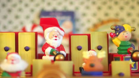 dorking, england - august 07 2018: christmas musical box showing santa claus and his helpers playing tunes on a toy xylophone. close up of santa claus toy.