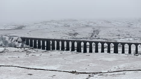 retiro estableciendo una toma aérea de un avión no tripulado del viaducto de ribblehead en las nieves de yorkshire dales, reino unido