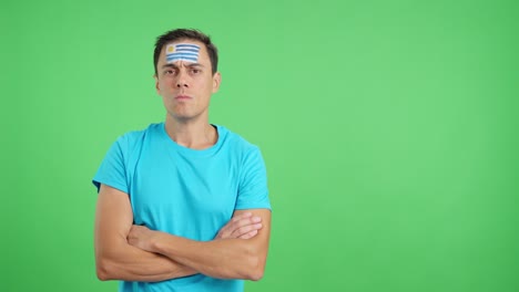 dignified and serious man with uruguayan flag painted on face