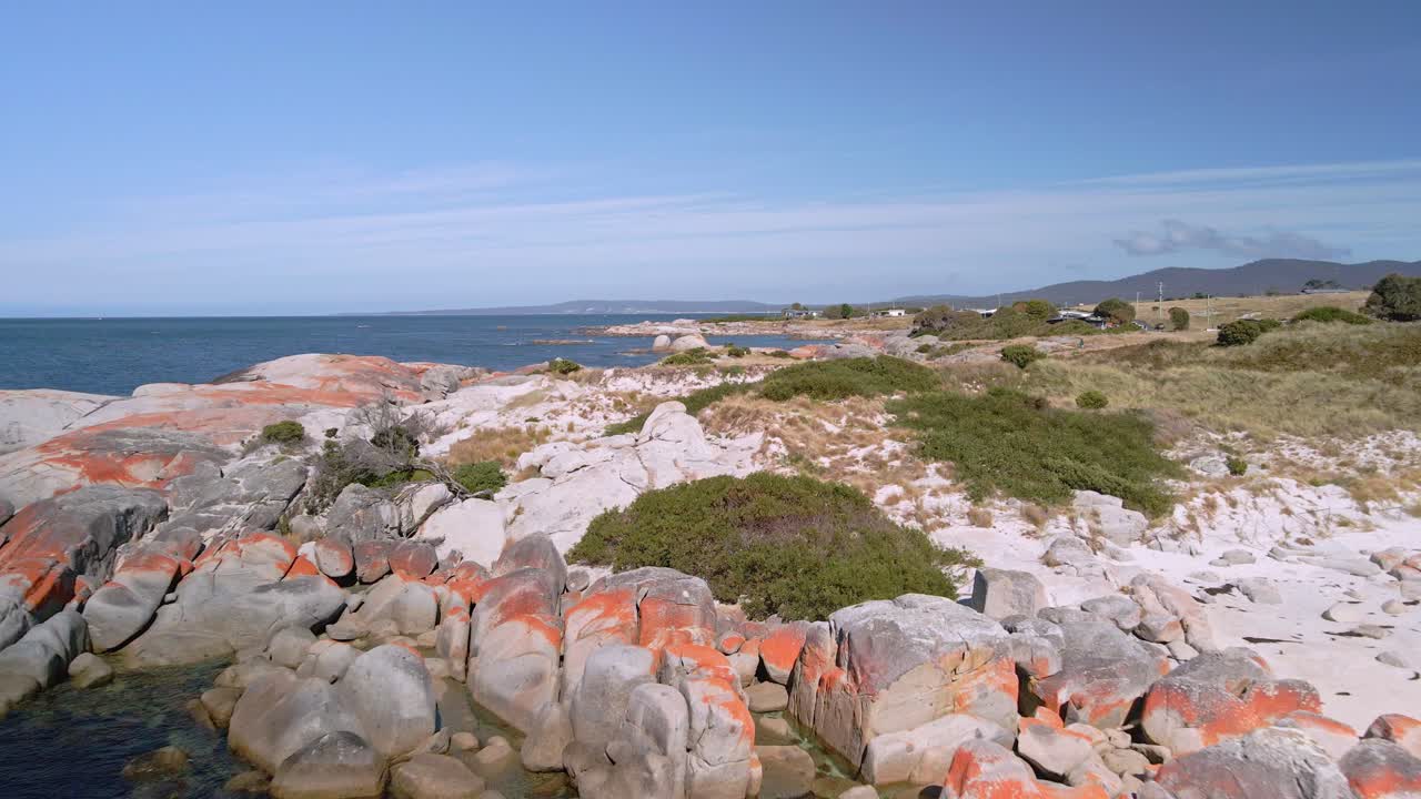 tomada de avión no tripulado de la costa de la bahía de los fuegos con rocas y rocas de granito naranja, tasmania, australia