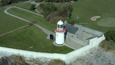 drone orbit shot above lighthouse at sea coast in summer, wide angle