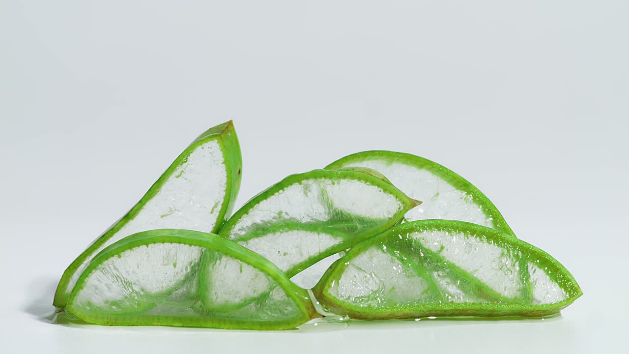 투명한 추출물 젤은 하 바탕에 잘라진 알로에 베라를 통해 흐릅니다. 유기 화장품, 대안 의학을위한 자연 의학 식물.