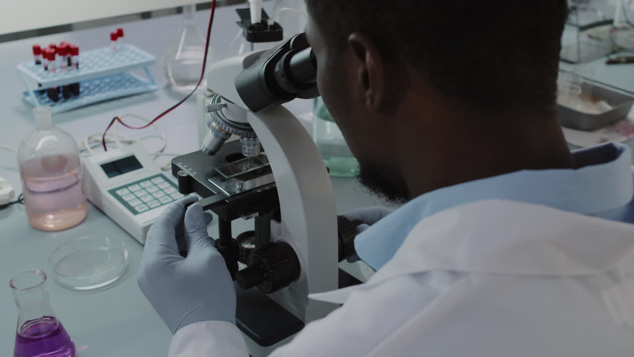 African-American Male Scientist Using Microscope