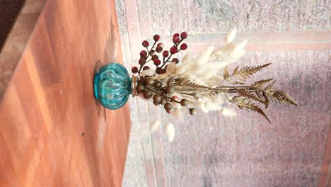 dried floral arrangement in a teal vase