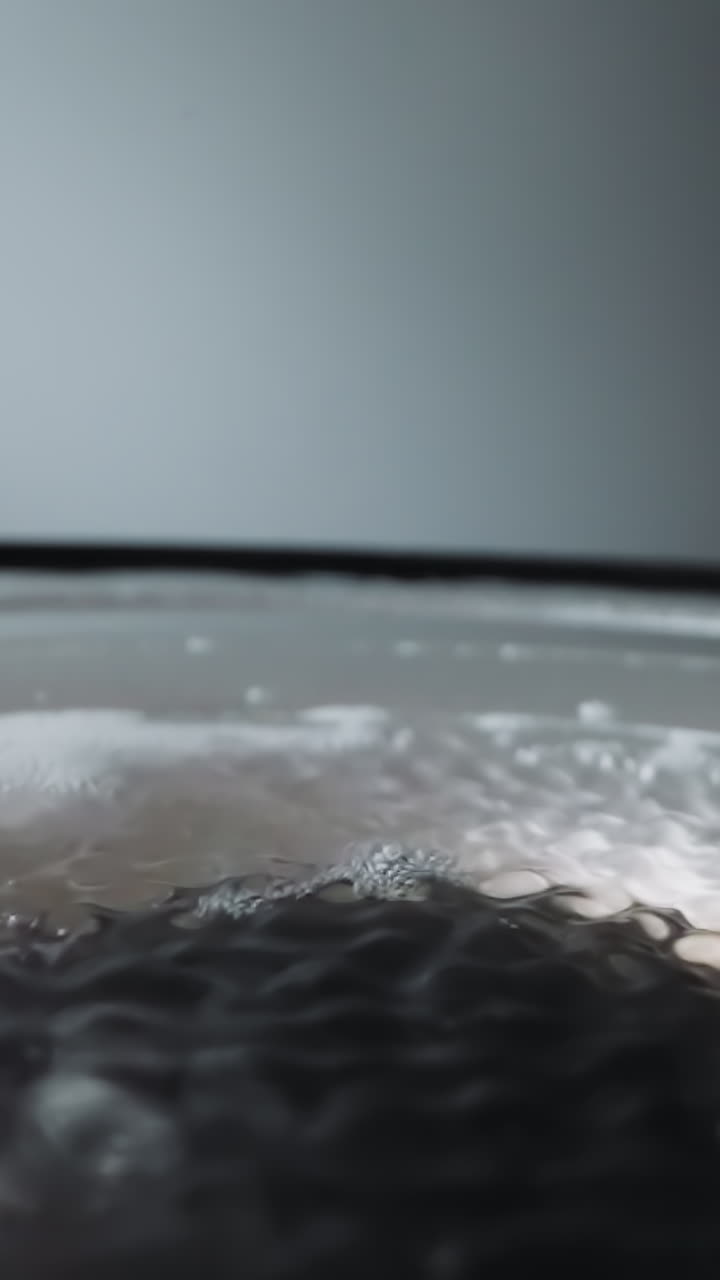 Speaker with transparent water and foam. Movement of dynamic diaphragm creates waves on surface of water. Forming of sound wave under liquid macro