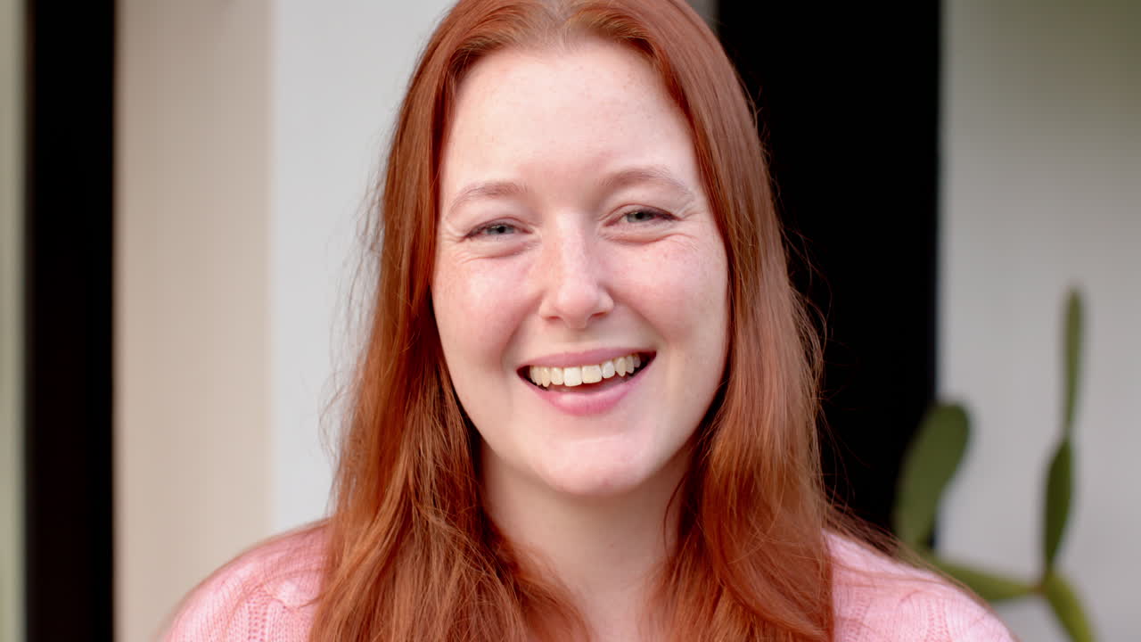 Smiling woman with red hair enjoying time with friends, looking happy and relaxed
