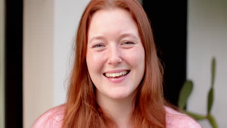smiling woman with red hair enjoying time with friends, looking happy and relaxed