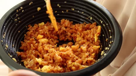 Eating-chicken-rice-in-a-take-away-plastic-bowl-,