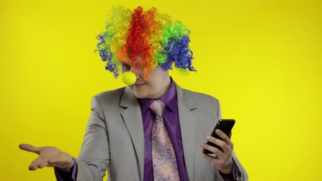 Clown-Geschäftsmann-Unternehmer-Chef-Erhält-Geldeinkommen,-Während-Er-Sein-Smartphone-Nutzt