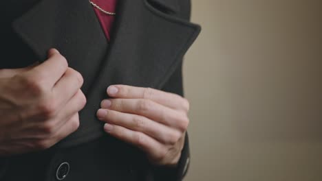 un tipo apuesto desabotonó su traje negro de cuatro botones con una camisa interior roja