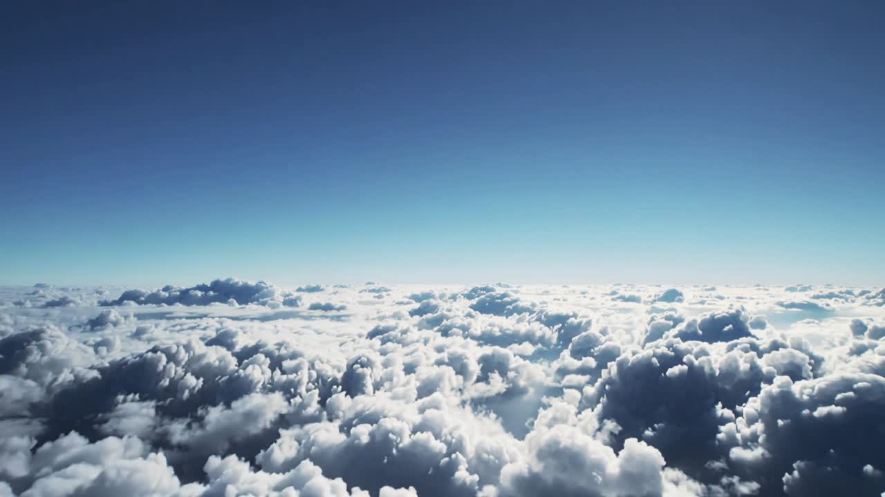 Moving camera revealing cumulus cloud layer over high-altitude view, showing distant horizon