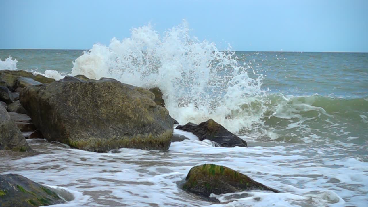 Onde del mare si infrangono contro le pietre. Riprese sulla costa. Slow motion