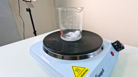 A time-lapse of sodium acetate crystallizing in a beaker on a hot plate under controlled lab conditions