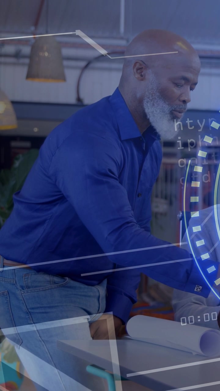 Vertikal video: Leder går hen til bord, læner sig over og glatter designplaner ud, mens en HUD-ring guider en kollega