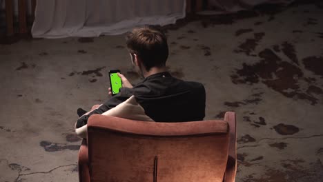 man using smartphone with green screen