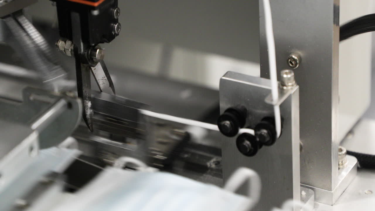 современный заводской станок с автоматическими ножницами для резки резины - производитель одноразовых масок - снимок крупным планом