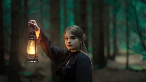 Young-woman-with-long-hair-holding-a-kerosene-lamp-in-a-dark-cold-forest