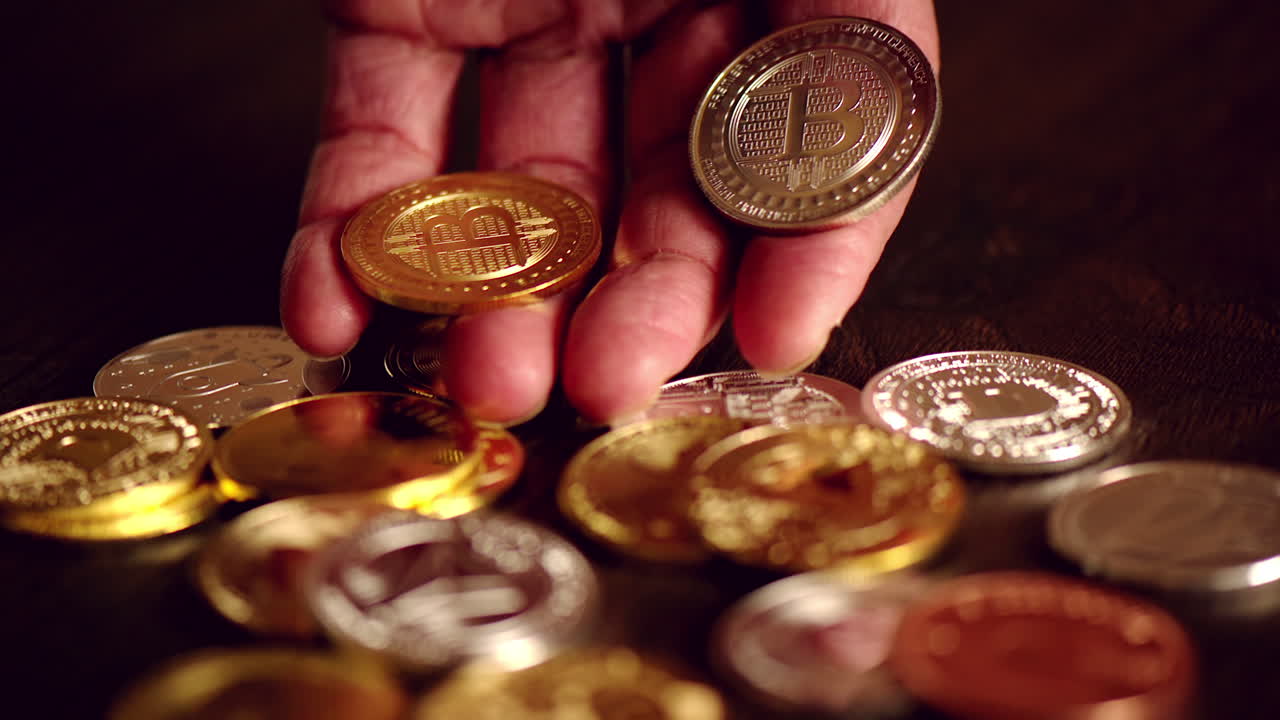 Man hand holding crypto coins and golden bitcoin on a table