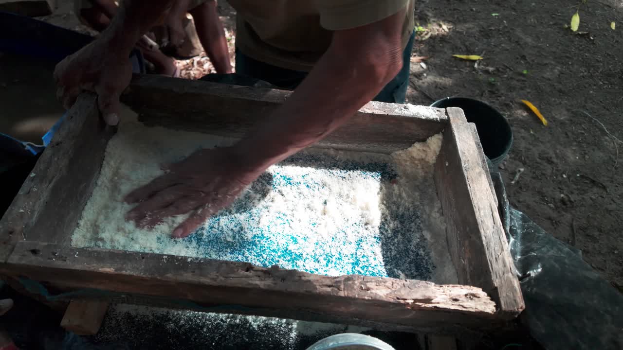 Working Hands Sifting a White Powder