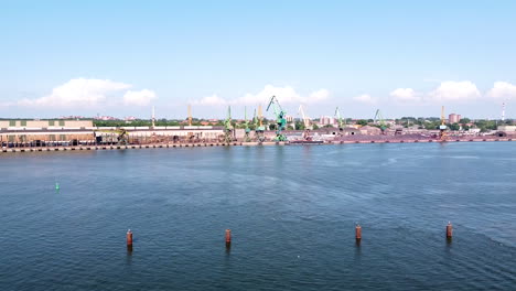 grúas industriales y edificios del puerto de klaipeda en un día soleado, vista descendente de drones