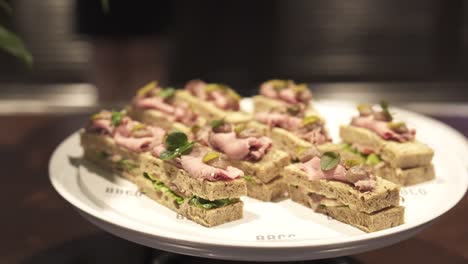 a plate finger foods, showcasing a variety of gourmet sandwiches at an elegant event buffet