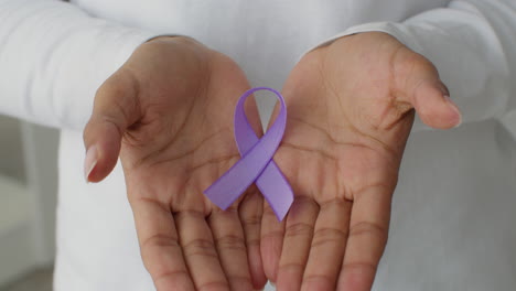 hands holding a purple ribbon
