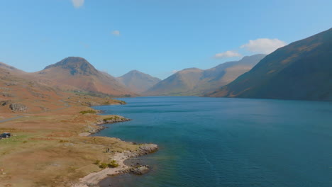 wastwater wasdale head lake district unesco national park, aerial sunrise pull back along lake with mountains