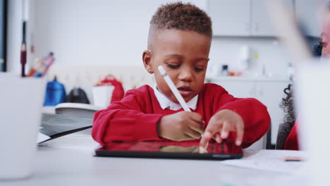 Junger-Schwarzer-Schuljunge-Zeichnet-Mit-Tablet-Computer-Und-Stift-In-Der-Vorschule,-Selektiver-Fokus