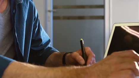 mid-section of male graphic designer using graphics tablet