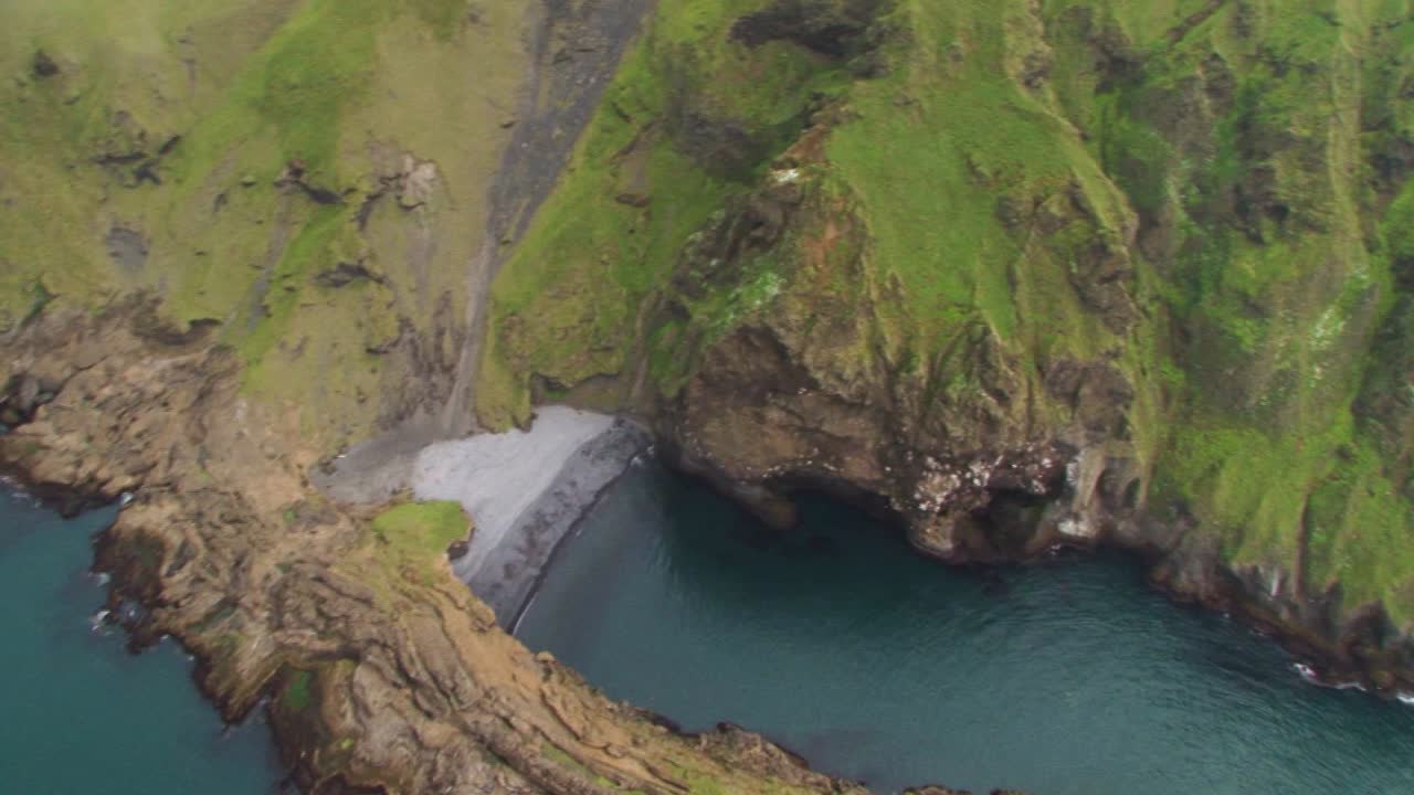 Aerial view of Iceland's green coastal cliffs, peaceful and stunning