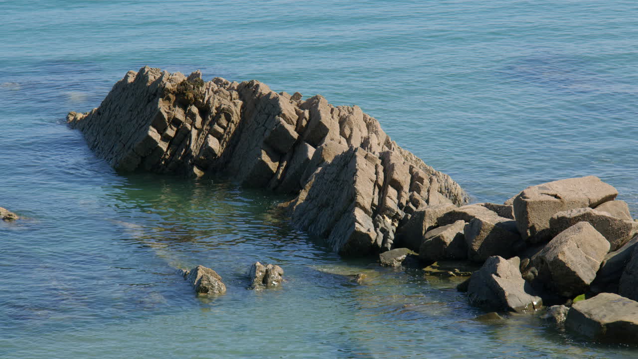 wide shot of exposed sedimentary rock at low tide at new quay, Wales
