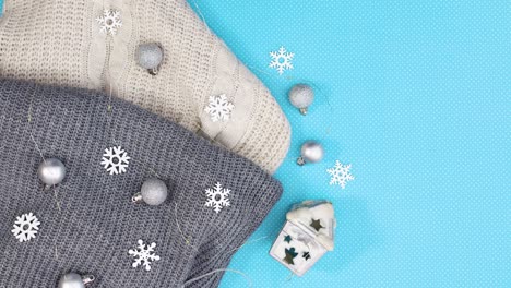 winter silver decoration with knitted wear appear on left side of blue theme. stop motion