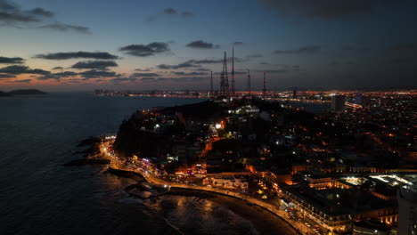 aerial view circling radio towers on the coast of mazatlan, colorful dusk in mexico