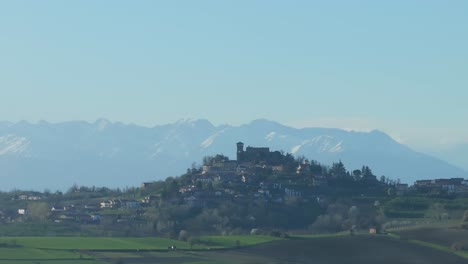 high,-snowcapped-mountains-in-the-north-of-Italy,-while-the-storybook-town-of-Gabiano,-Italy-is-in-the-foreground,-cinematic-introduction