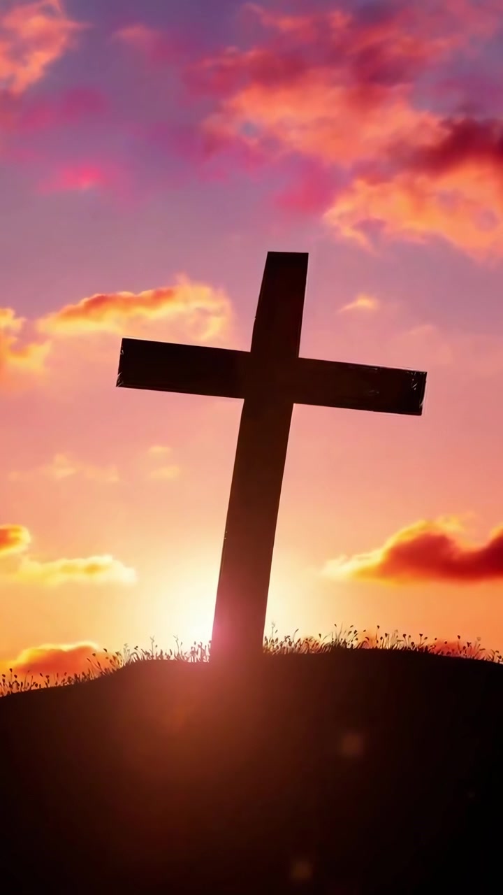 Silhouette di una croce cristiana contro un cielo vibrante al tramonto.