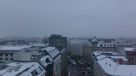 Forwards-fly-above-streets-in-urban-neighbourhood-in-winter.-Vehicles-and-trams-driving-in-street-surrounded-by-apartment-houses.-Berlin,-Germany