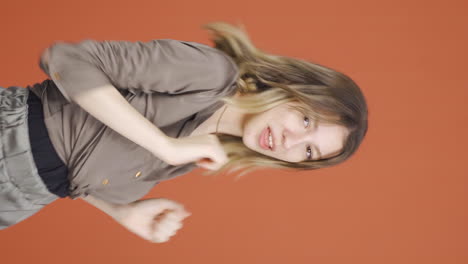 Vertical-video-of-Happy-young-woman-dancing.