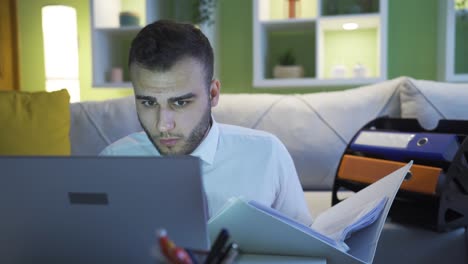 hombre de negocios trabajando con computadora portátil y carpetas en la sala de estar.