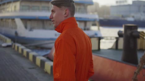 harbor worker in orange uniform is walking on cargo harbor site. slow motion