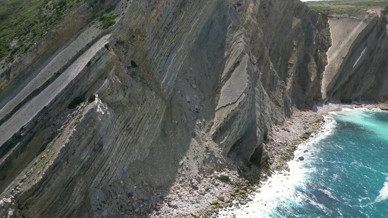 Aerial drone footage of Cabo Espichel, Portugal: dramatic Atlantic cliffs, rugged coastline and vast ocean landscape under natural light. Ideal for travel and nature projects.