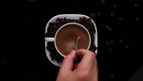 top view hand stirring coffee with spoon