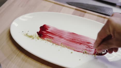 chef rubbing jam on plate