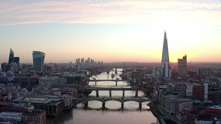 Cinematic dolly forward aerial drone shot of sunrise over Thames river and central London