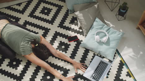 top view of woman practicing yoga at home