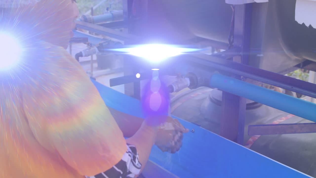 animación de luces y destellos de lentes sobre una mujer afroamericana lavando las manos al aire libre en standpipe